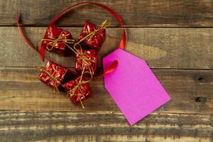 elementos decorativos de natal ao lado do cartão com fita vermelha e espaço para escrever foto