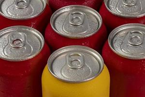 latas de refrigerante vermelhas frias com uma amarela para uso conceitual foto