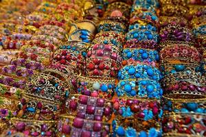 uigur mulheres tradicional e colorida pulseira joalheria em uma fornecedor dentro a grande bazar dentro urumqi, xinjiang, China foto