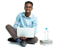 feliz africano americano Faculdade aluna com computador portátil, livros e garrafa do água sentado em branco foto