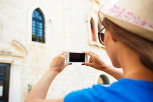 menina dentro chapéu fazer fotos do uma Igreja de a Smartphone