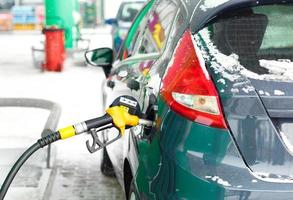 carro reabastecimento em uma gasolina estação dentro inverno foto