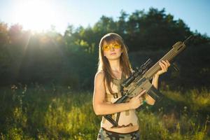 jovem fêmea soldado com máquina arma de fogo foto
