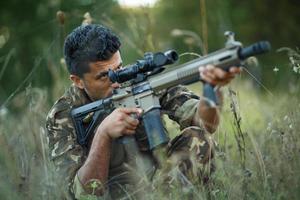 jovem masculino soldado com máquina arma de fogo foto