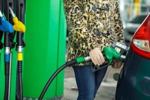 mulher preenche gasolina para dentro dela carro às uma gás estação dentro inverno foto