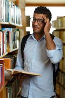 jovem homem dentro a biblioteca foto