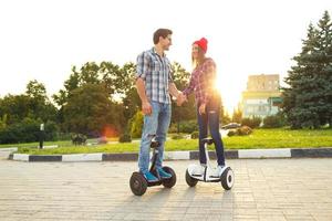 uma jovem casal equitação hoverboard - elétrico lambreta, pessoal eco transporte, giroscópio lambreta, inteligente Saldo roda foto