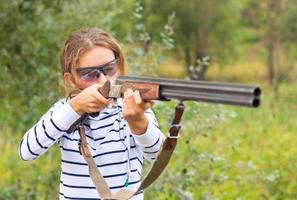 uma jovem menina com uma arma de fogo para armadilha tiroteio foto