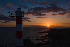 farol sobre a pôr do sol foto