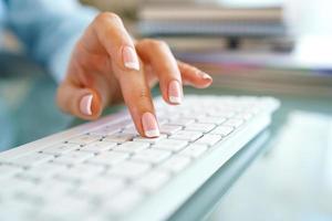 mulher escritório trabalhador digitando em a teclado foto