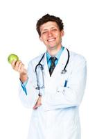 retrato do uma sorridente masculino médico segurando verde maçã em branco foto