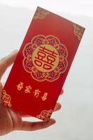 mão segurando vermelho envelope presente chinês Novo ano foto