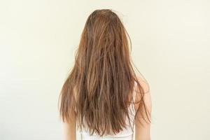 estragado cabelo, frustrado ásia jovem mulher, menina dentro divisão termina, bagunçado não escovado seco cabelo e crespo com grandes desgrenhado cabelo, saúde Cuidado do beleza. retrato isolado em fundo, costas visualizar. foto