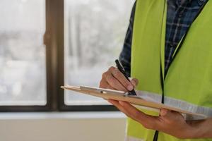 construção inspeção, contratante ásia jovem homem, masculino inspecionando lar, reconstruído construção, renovação ou Verifica defeito, antes terminar entrega isto sobre para cliente. Engenharia trabalhador, cópia de espaço. foto