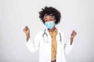 feliz satisfeito fêmea africano americano médico vestindo protetora face mascarar e segurança óculos, olhos sorrindo, estúdio retrato isolado ,contente alívio depois de fim do global cobiçado 19 pandemia crise foto