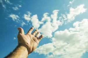 mão do uma homem elevado acima para a céu. foto