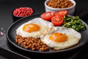 delicioso forte café da manhã consistindo do dois frito ovos, enlatado lentilhas e microgreens foto