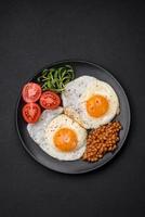 delicioso forte café da manhã consistindo do dois frito ovos, enlatado lentilhas e microgreens foto