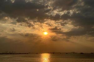 céu pôr do sol no cenário da praia, sejam os tons quentes de um nascer ou pôr do sol, reflexo cintilante do sol nas nuvens, o céu e as nuvens têm o poder de inspirar sentimentos de admiração e admiração foto