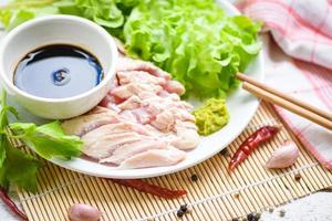 sashimi cru frango em branco prato com wasabi molho e vegetal salada alho Pimenta ervas e especiarias tradicional japonês Comida - frango fatias carne filé foto