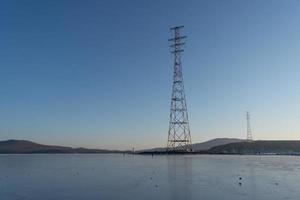 paisagem marítima de água e montanhas com torres de transmissão de eletricidade em Vladivostok, Rússia foto