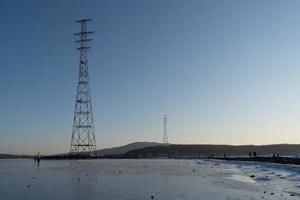 paisagem marítima de água e montanhas com torres de transmissão de eletricidade em Vladivostok, Rússia foto