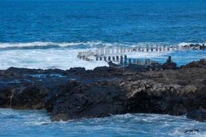 ampla ondas falhando contra a pedras dentro a oceano foto