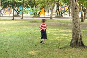 Garoto corrida dentro a jardim foto