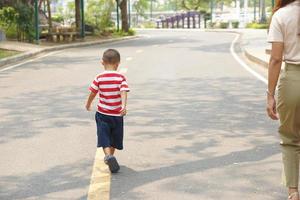 mãe leva bebê para uma andar dentro a parque feriado foto