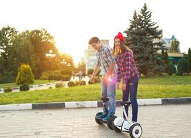 uma jovem casal equitação hoverboard - elétrico lambreta, pessoal eco transporte, giroscópio lambreta, inteligente Saldo roda foto