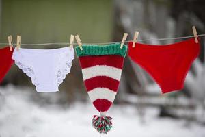 mulheres calcinhas e uma Natal chapéu estão seco em uma corda. foto