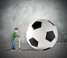 jovem criança com grande futebol bola foto