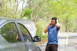 homem chamado uma mecânico para venha Veja às a quebrado carro. foto