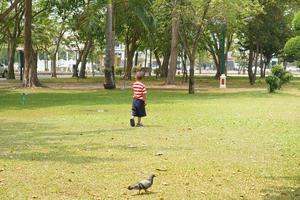 Garoto corrida dentro a jardim foto