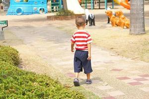 Garoto corrida dentro a jardim foto