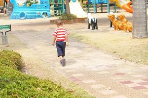 Garoto corrida dentro a jardim foto