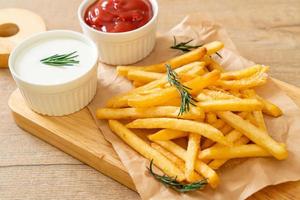 batatas fritas com creme de leite e ketchup foto