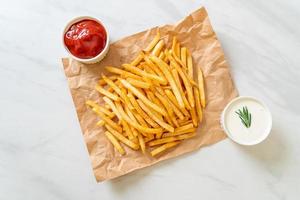 batatas fritas com creme de leite e ketchup foto