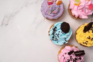 deliciosos cupcakes caseiros com creme colorido e cobertura com biscoitos doces e chocolate. sobremesa caseira de férias de outono foto