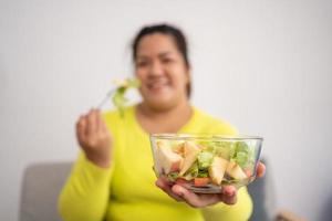 grávida asiática aprenda a cozinhar refeições saudáveis da internet na cozinha, mulheres gordas preparam uma salada de legumes para dieta alimentar e perdem peso. conceito de alimentação saudável foto