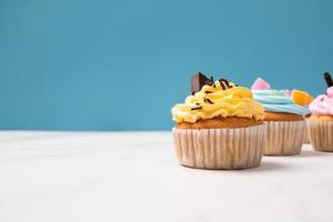 deliciosos cupcakes caseiros com creme colorido e cobertura com biscoitos doces e chocolate. sobremesa caseira de férias de outono foto