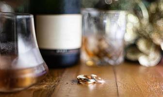 Casamento argolas em rústico de madeira mesa com uísque e champanhe. foto