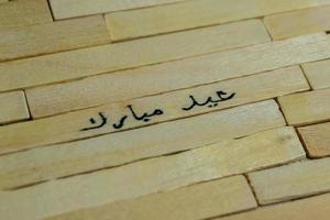 islâmico citações. eid Mubarak palavras escrito em de madeira grudar. foto