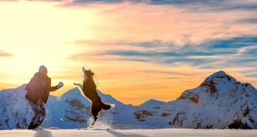 garota brincando com border collie na neve foto