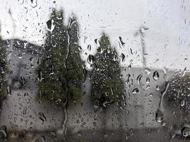 uma pingos de chuva gotejamento baixa a parabrisa do a carro. para pingos de chuva fundo. não pessoas foto