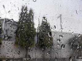 uma pingos de chuva gotejamento baixa a parabrisa do a carro. para pingos de chuva fundo. não pessoas foto