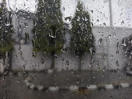 uma pingos de chuva gotejamento baixa a parabrisa do a carro. para pingos de chuva fundo. não pessoas foto