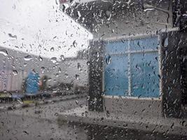 uma pingos de chuva gotejamento baixa a parabrisa do a carro. para pingos de chuva fundo. não pessoas foto