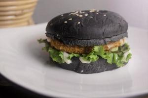 Preto hamburguer em branco prato a partir de frente ângulo fotografia foto