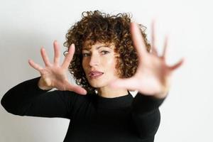 focado mulher alongamento braços e mostrando Pare gesto com cheio aberto Palmeiras foto